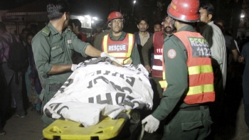 Rescue workers move a body from the blast site 