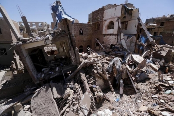 People stand at the site of a recent Saudi-led air strike in Yemen&#039;s capital Sanaa, September 11, 2015. 
