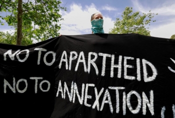  Un manifestante israeliano regge uno striscione di protesta contro il piano di pace statunitense, Gerusalemme, 15 maggio