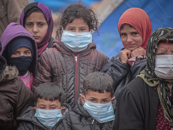 Dei bambini siriani e una donna anziana indossano le mascherine chirurgiche, Idlib 