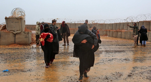Mothers shielding their children from the harsh weather conditions in Rukban