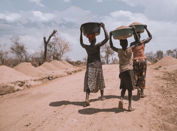 Tre donne camminano su una strada africana sterrata