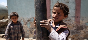 Bambino con in mano un pezzo di artiglieria esploso, trovato in un sobborgo di Sana&#039;a, la capitale dello Yemen
