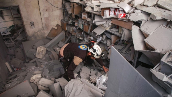 A member of the Syrian Civil Defense searches for survivors in the rubble of a hospital in Darat Izza, 30 kilometers northwest of Aleppo