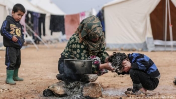 Una donna siriana si prende cura dei suoi bambini in un villaggio rurale 