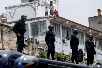 Mexican riot police keep watch over protesters from a teachers union as they take part in a march against President Enrique Peña Nieto&#039;s education reforms, in Mexico City on June 3. 