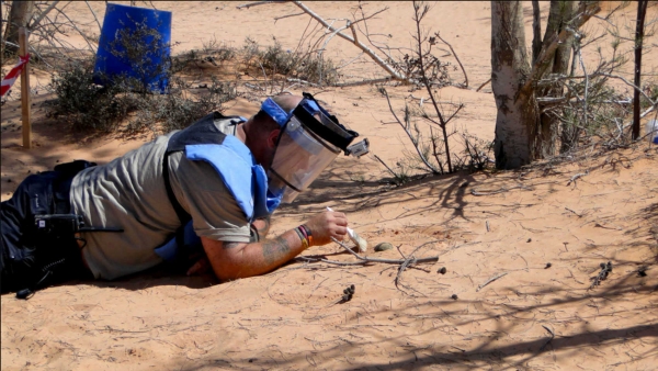Un esperto prova a disinnescare una mina antiuomo attiva a Tripoli, Libia