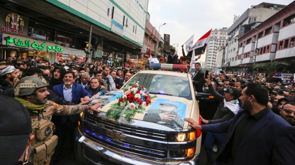 Mourners surround a vehicle carrying the coffins of Iranian Maj