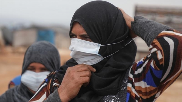 Donne con maschere chirurgiche nei campi profughi siriani a Idlib.