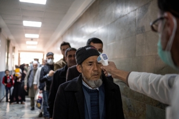 Travelers have their temperature taken before entering Kabul airport, March 16, 2020