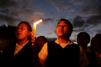 Un ragazzo regge una candela durante la veglia per le vittime del rogo alla casa di accoglienza Virgen de la Asuncion