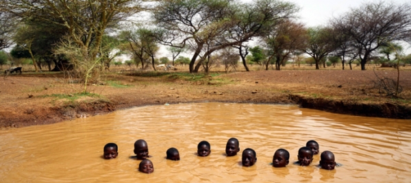 Bambini che nuotano in una pozza d’acqua in Burkina Faso