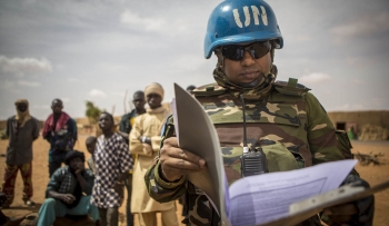 Peacekeeper of the UN Mission in Mali (MINUSMA) handling policy and guidance materials