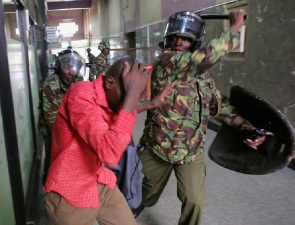 Policemen beat a protester inside a building during clashes in Nairobi, Kenya May 16, 2016.  