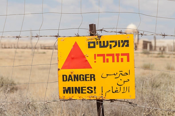 Segnale di pericolo di presenza di mine terrestri vicino a una chiesa nel deserto israeliano