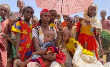 Donne e bambini aspettano in un centro di distribuzione di alimenti nel Tigray, in Etiopia. 