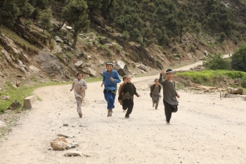 Bambini corrono su un selciato desolato