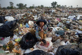 Bambina mentre mangia spazzatura e cibo sprecato  
