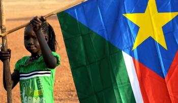 Una bambina con in mano una bandiera sud sudanese. Crediti della foto: 