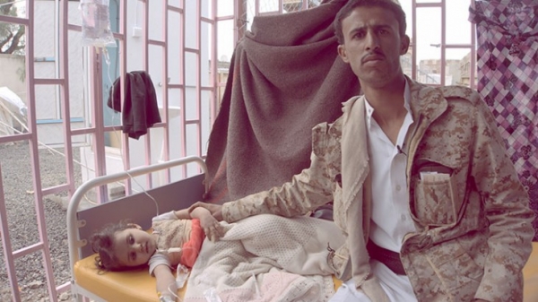 Una giovane ragazza con il colera siede accanto al padre in Yemen