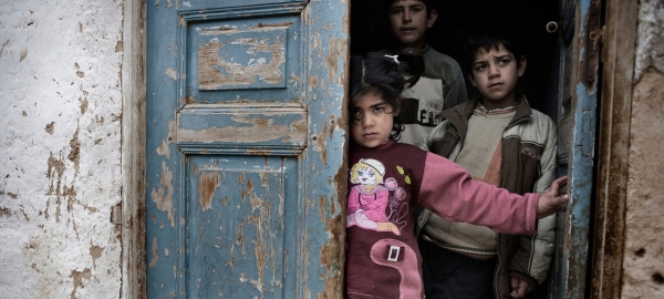 Syrian children in the doorway of a house.