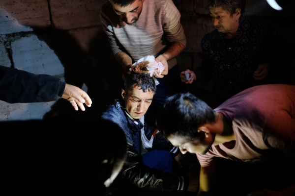 Alcune persone soccorrono un uomo ferito durante i bombardamenti a Stepanakert, il 4 ottobre 2020