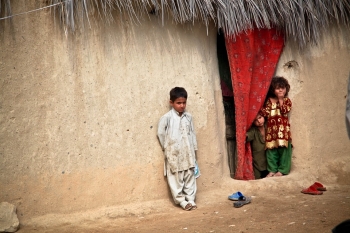 Children leaning against the wall of a shelter