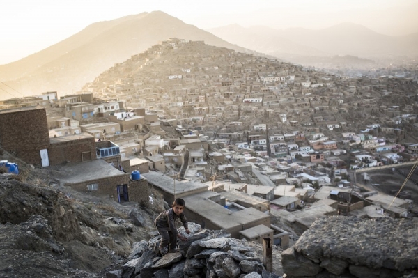 A boy climbs a rock in Kabul
