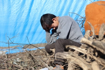 Bambino seduto in un campo rifugiati.