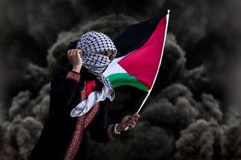 Una donna sventola la bandiera palestinese. 
