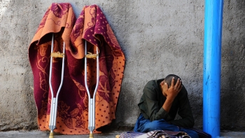 Un uomo siede fuori da una struttura di salute mentale nella città di Herat