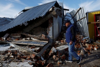 Man walking across its destroyed house in Balakliia, Ukraine.