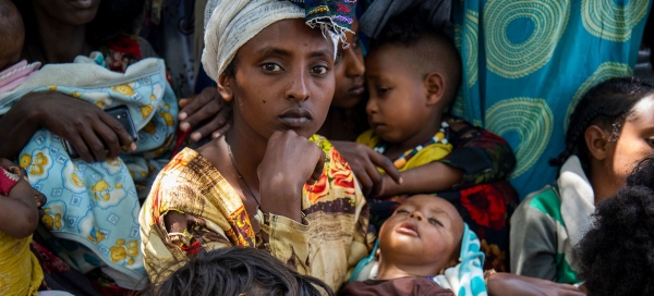 Una donna con il suo bambino aspettano in fila, insieme a molti altri, per essere visitati nella clinica del Sud Tigray.