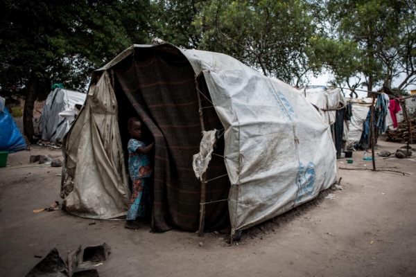 Child standing outside a tent in displacement site nearby Bunia (Kasenyi)