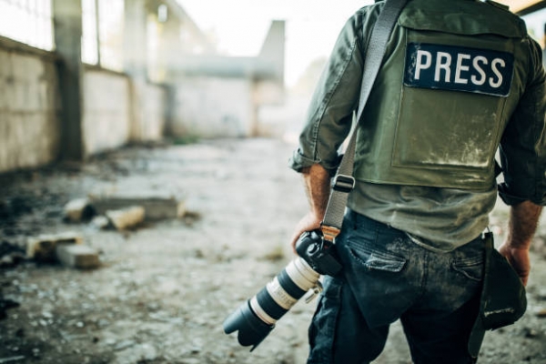 Un giornalista di guerra in un edificio distrutto