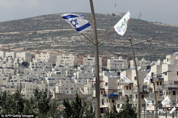 An Israeli flag flies high in front of a Jewish settlement in the area of Jerusalem 