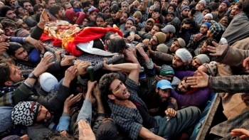 Il corpo senza vita di un combattente viene sollevato dai civili Kashmiri durante una protesta