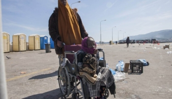 A mother of a child with disability pushes her wheelchair