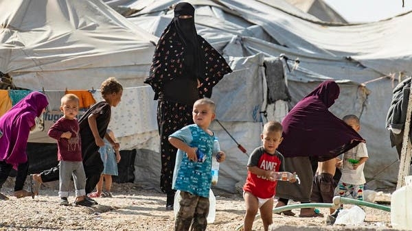 Donne che guardano giocare i bambini nel campo di al-Hol