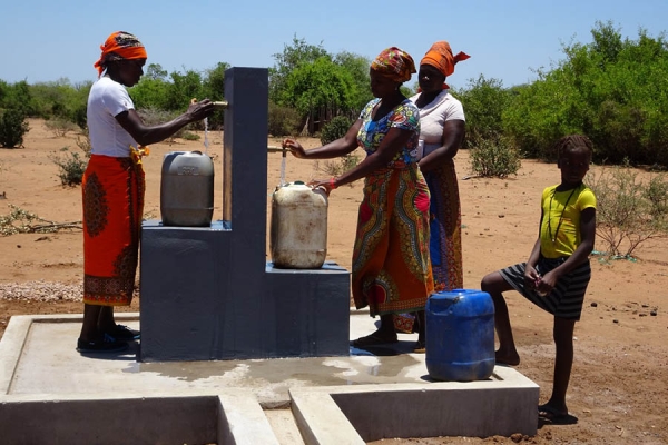 Alcune donne in Africa mentre riempiono taniche d’acqua potabile