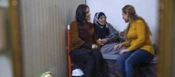 Refugee talking to her mother and sister in Akre camp where she provides mental health support to other refugees