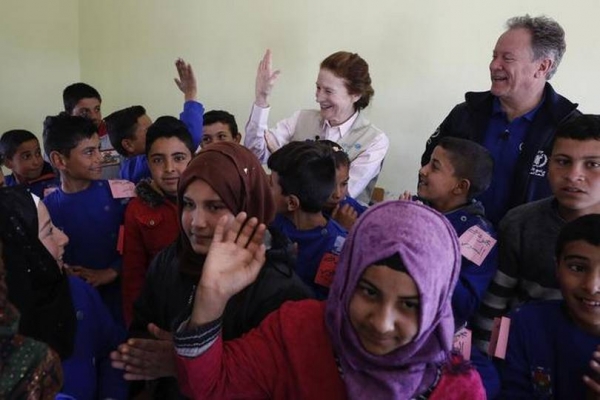 UNICEF and World Food Programme officials interact with children at a school in southern Idlib in Syria in March