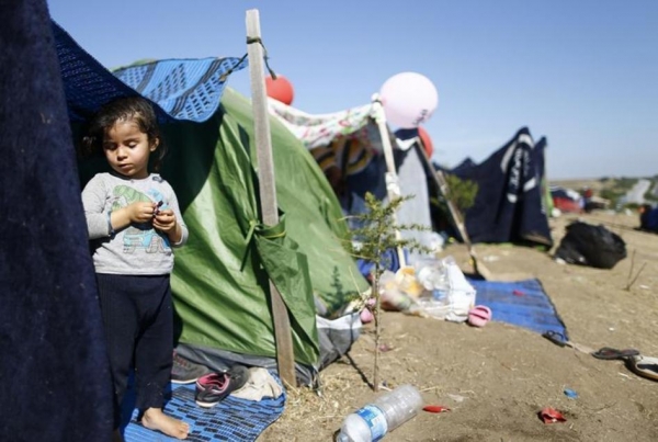 A Syrian child stands in a tent on the side of a highway near Edirne, Turkey.