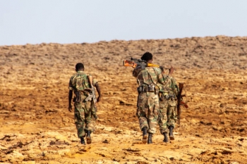 Three Ethiopian soldiers walking in the desert 