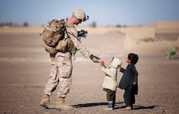 US Marine hands a toy to a child during a patrol mission in Afghanistan 