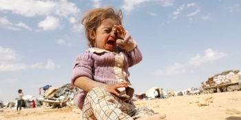 Syrian child crying lost and alone in a refugee camp