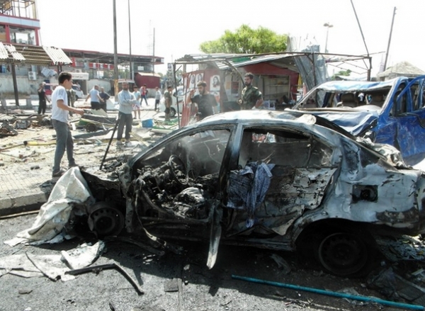 A burnt-out car at the scene of one of multiple bombings in Tartus