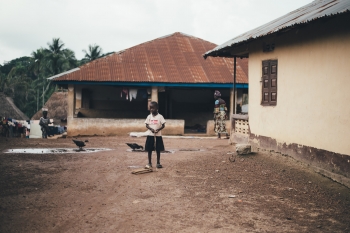 Bambino in mezzo a delle case di un villaggio