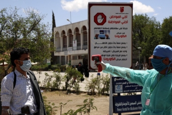 Operatori sanitari yemeniti misurano la temperatura di un uomo utilizzando un termometro a infrarossi all’ingresso di un ospitale locale