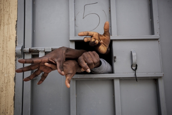 Sub-Saharan migrants and refugees begging for their release in a detention center in Surman, Libya